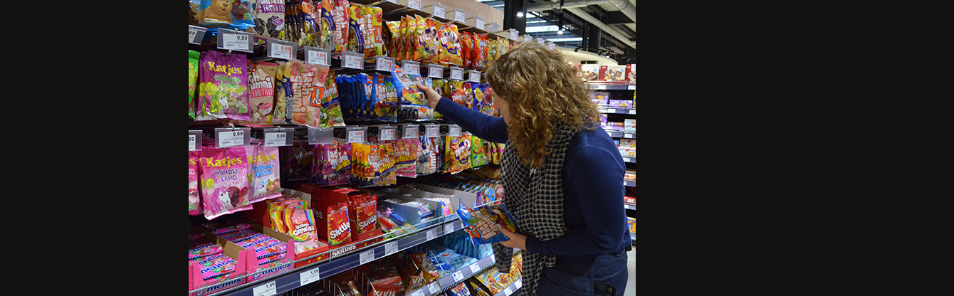 Foto von Stephanie Senge, die im Supermarkt in der Süßwarenabteilung einkauft.