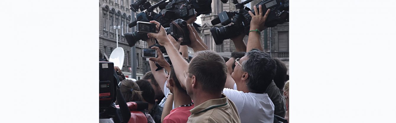 Auf dem Bild sieht man viele Paperazzi, welche ein unbekanntes Motiv fotografieren