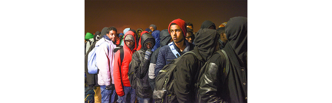 Daniel Biskup, Calais, Oktober 2016, Bild zeigt eine anstehende Gruppe junger Männer zumeist mit Hoodie oder Mütze